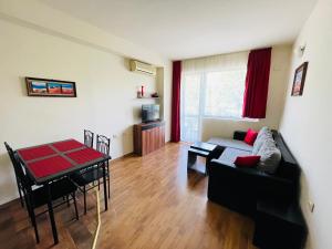 a living room with a couch and a table at Black Sea View Apartments in Ravda