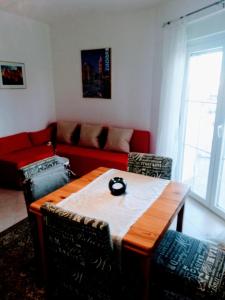 a living room with a table and a red couch at Villa Maslina in Zadar