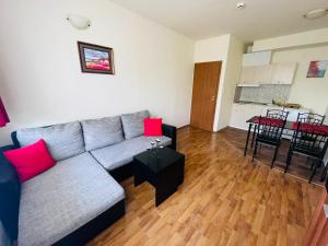 a living room with a gray couch and red pillows at Black Sea View Apartments in Ravda