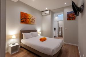 a bedroom with a bed with an orange pillow on it at Hotel l'Hotera in Cannes