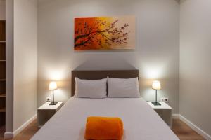 a bedroom with a large bed with two lamps at Hotel l'Hotera in Cannes