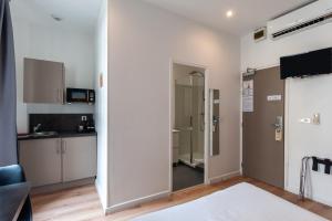 a living room with a door leading to a kitchen at Hotel l'Hotera in Cannes