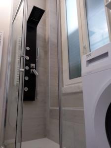 科拉托的住宿－Paoli 28 Holiday Homes，淋浴玻璃门,旁边是洗衣机