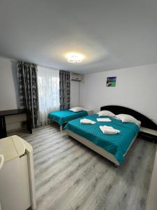 - une chambre avec 2 lits avec des draps bleus dans l'établissement Vila Iris Mamaia Nord, à Mamaia Nord – Năvodari