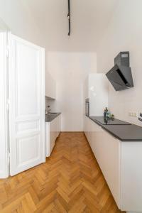 una cucina con armadietti bianchi e pavimenti in legno di Joseph I levestate a Vienna