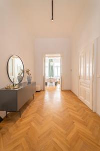 ein Wohnzimmer mit einem Spiegel und Holzboden in der Unterkunft Joseph I levestate in Wien