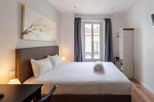 a bedroom with a bed with a hat on it at Hotel l'Hotera in Cannes