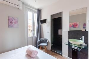 a bedroom with a bathroom with a sink and a mirror at Hotel l'Hotera in Cannes
