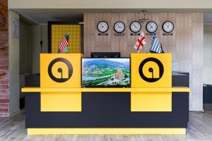 un mostrador amarillo y negro con TV. en Aura Plaza Hotel, en Tiflis
