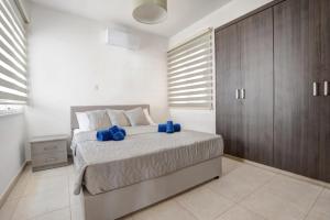een slaapkamer met een bed met blauwe kussens erop bij Nissi Villa Sotia in Ayia Napa +41 foto's
