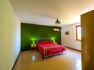 una camera con un letto rosso su una parete verde di Masseria Brica Rossa a Thurio