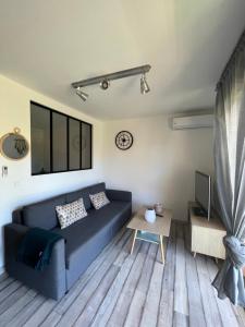 a living room with a blue couch and a table at Chez Mel et Manu in Sanary-sur-Mer