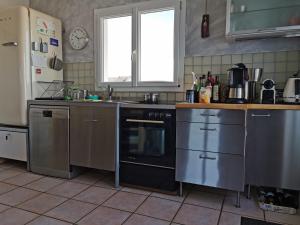a kitchen with a stove and a sink and a refrigerator at Das Haus auf der Düne in Plouescat +12 photos
