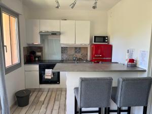 uma cozinha com um balcão e um frigorífico vermelho em Chez Mel et Manu em Sanary-sur-Mer