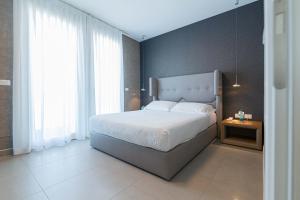 a bedroom with a large bed with a large window at Mosella Suite Hotel in Sottomarina