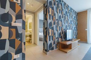 a room with a wall with a tv and a table at Mosella Suite Hotel in Sottomarina