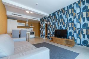 a living room with a couch and a television at Mosella Suite Hotel in Sottomarina