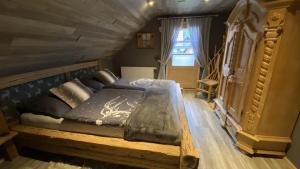 a bedroom with a wooden bed in a attic at Chalet am Weißenbach in Hinterstoder