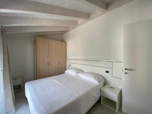 a white bedroom with a large white bed and cabinets at Royal apt Colico Lake Como in Colico
