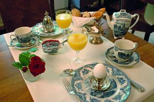a table with plates and cups and glasses of orange juice at Hotel Miramar in Hamburg