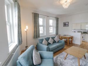 a living room with a blue couch and a table at Bluewater View in Saltburn-by-the-Sea