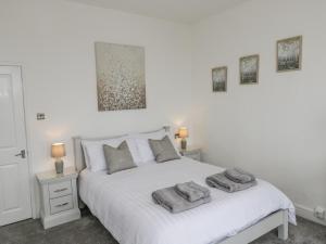 1 dormitorio con 1 cama blanca y 2 almohadas en Bluewater View, en Saltburn-by-the-Sea