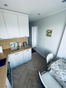 - une cuisine avec des placards blancs et un lit dans une chambre dans l'établissement Gdynia Centrum, à Gdynia