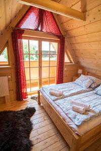 pokój z 2 łóżkami w drewnianym domku w obiekcie Bajkowa Osada Murzasichle domek z jacuzzi w Murzasichlu