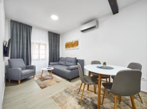 - un salon avec un canapé, une table et des chaises dans l'établissement Cardo Apartments, à Poreč