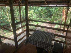 a room with a table and a view of a forest at Kuporo lodge in Quince Mil
