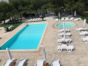 an empty swimming pool with lounge chairs and a group ofitures at Casa Antonia in Mesagne