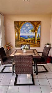 a dining room table with chairs and a painting on the wall at lovely 2BED 2BA vacation rental near the Beach in Pompano Beach