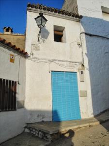 eine blaue Tür an der Seite eines weißen Gebäudes in der Unterkunft Casa de Pueblo - Costa Blanca in Oliva
