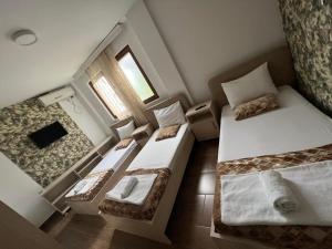 a small room with two beds and a window at Hotel Ultra Star in Skopje