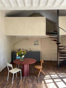 une chambre avec une table, des chaises et un escalier dans l'établissement guesthouse L'Officine, à Lincent