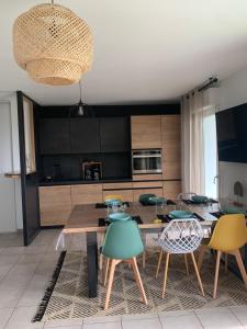 a kitchen with a wooden table and chairs at Bayonne Appartement terrasse 4 km plage in Bayonne