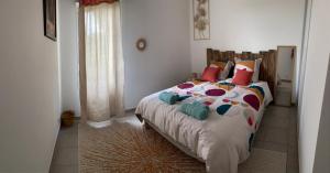 a bedroom with a bed with colorful pillows on it at Appartement Baiona in Bayonne +1 photo