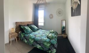 - une chambre avec un lit doté d'oreillers verts et d'une fenêtre dans l'établissement Bayonne Appartement terrasse 4 km plage, à Bayonne