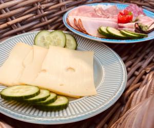 two plates of cheese and cucumbers on a table at De Vijverkamer-----privé diner op de kamer mogelijk!! in Hoogeveen