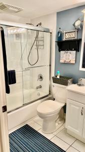 uma casa de banho branca com um chuveiro e um WC. em lovely 2BED 2BA vacation rental near the Beach em Pompano Beach