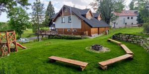 a house with a yard with benches in front of it at Chalupa Granát in Kořenov