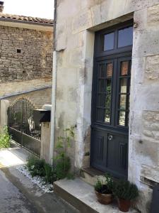 a black door on the side of a building at La Cour Blanche in Verteuil-sur-Charente