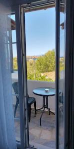 a table and chair on a balcony with a view at Enalia Studio in Korissia