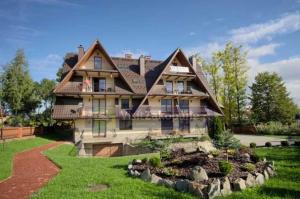 a large house with a landscaping in the yard at VisitZakopane - Mount Everest Apartment in Zakopane
