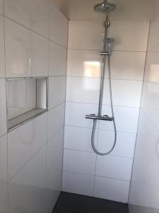 ducha de azulejos blancos con cabezal de ducha en Villa Am Honigbach, en Coesfeld