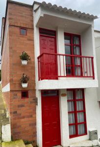 una casa con una porta rossa e un balcone di Casa Roma - La tranquilidad del campo en la Ciudad - RNT 1 0 8 1 3 7- a Salento