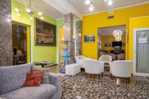 リド・ディ・イエゾロにあるHotel Ragnoの黄色の壁のリビングルーム(ソファ、椅子付)