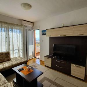 a living room with a couch and a large television at Apartman Nadja in Budva