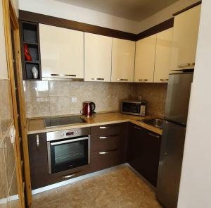 a kitchen with white cabinets and a stove top oven at Apartman Nadja in Budva