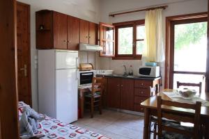eine Küche mit einem weißen Kühlschrank und einem Tisch in der Unterkunft Sophie's traditional hospitality appartment in Monemvasia